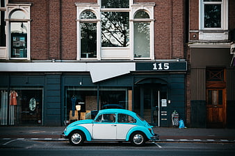 Vintage turquoise and white Volkswagen Beetle parked on city street