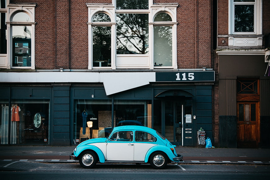Vintage turquoise and white Volkswagen Beetle parked on city street