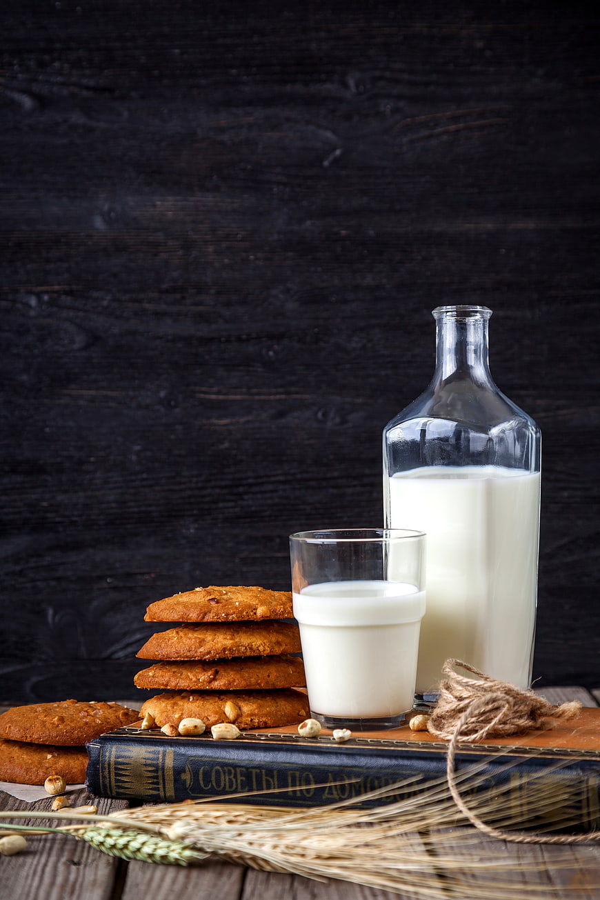 Stack of oatmeal cookies with milk on rustic wooden table