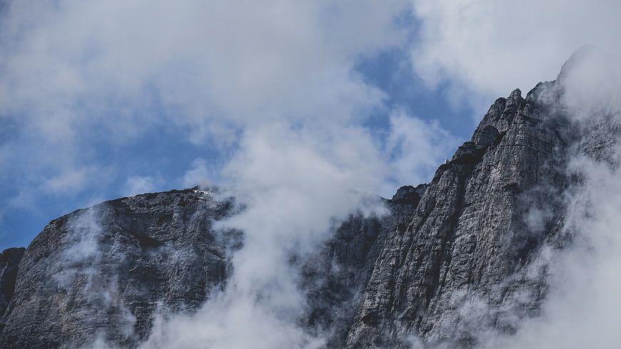 Majestic Rocky Mountain Peak Shrouded in Mist and Clouds