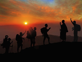 Silhouettes of Hikers and Monk Greeting at Mountain Sunset