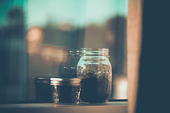 Glass Jars with Dried Herbs on a Window Sill