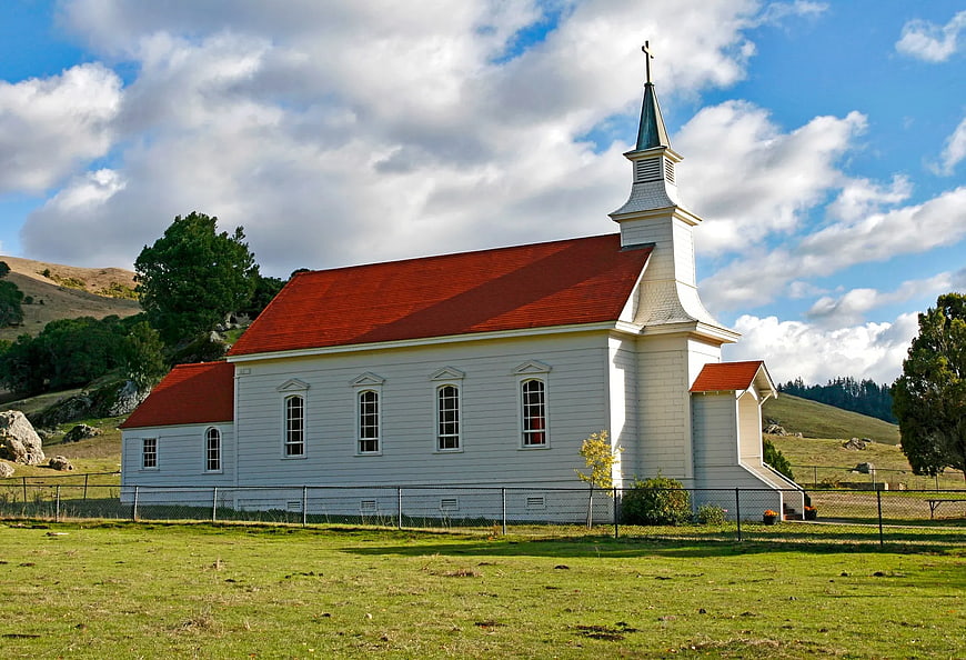 White Church with Red Roof in Rural Landscape