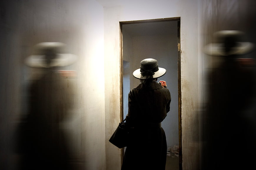 Woman in Hat Taking Mirror Selfie in Dim Room