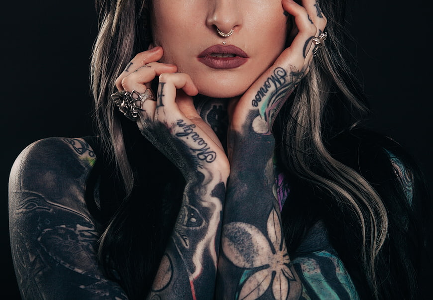 Portrait of tattooed woman with dark makeup and rings