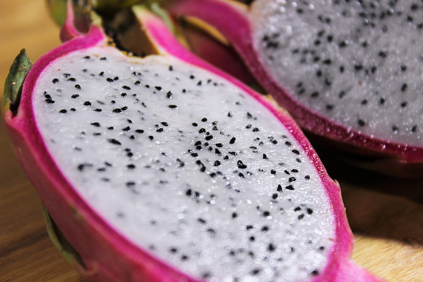 Close-up of sliced white dragon fruit on wooden board