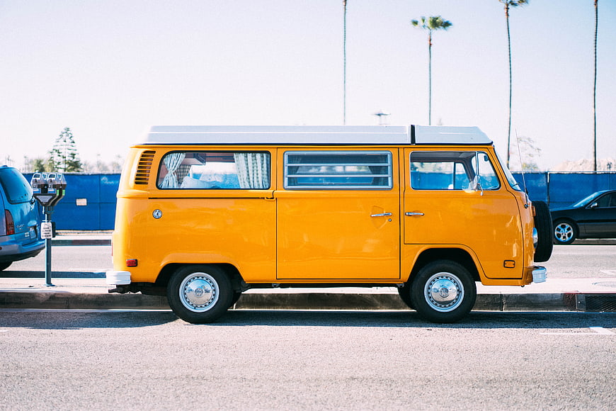 Yellow Vintage VW Bus Parked on Sunny Street