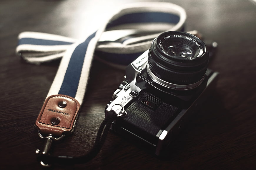 Vintage Olympus OM-10 Film Camera on Wooden Table