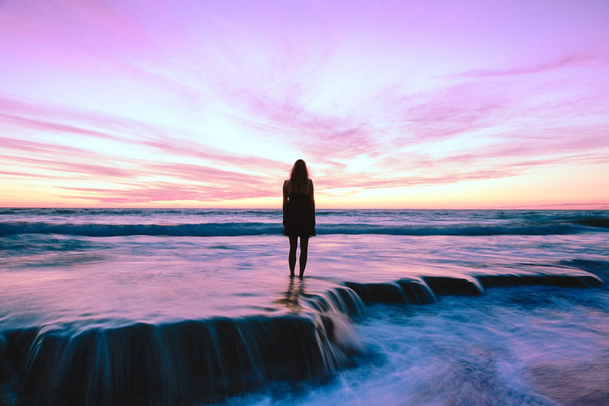 Woman Silhouette Standing on Beach at Pink Sunset