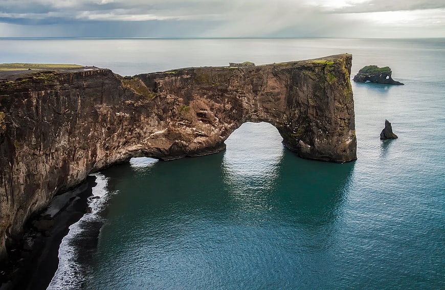 Dramatic Coastal Cliff with Natural Rock Arch Over Ocean