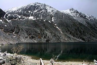 Snowy mountain peak reflected in calm alpine lake