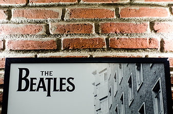 The Beatles framed poster on red brick wall