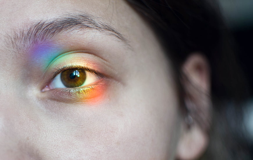 Close-up of woman's eye with rainbow makeup