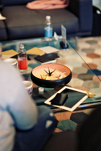 Origami cranes in bowl on glass coffee table