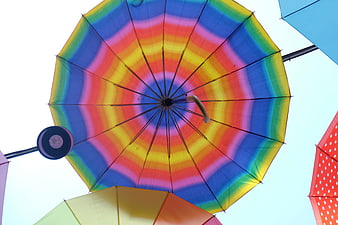 Colorful rainbow umbrella viewed from below against sky