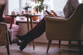 Woman using smartphone in cozy cafe interior