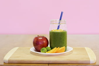 Green Fruit Smoothie with Apple and Oranges on Pink Background