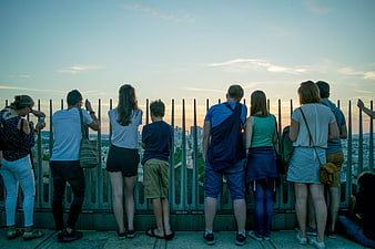 Group of Tourists Watching Sunset Over City Skyline