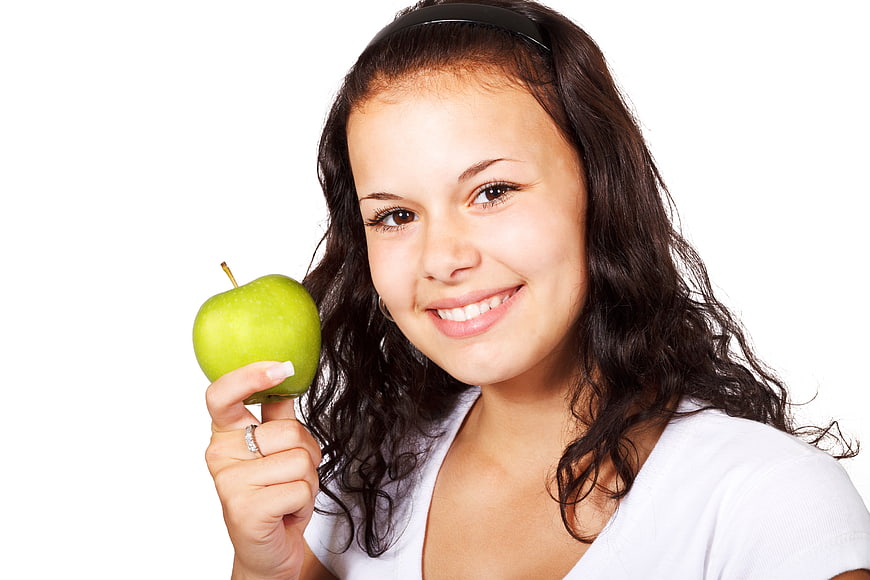 Smiling Woman Holding Green Apple on White Background