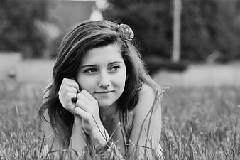 Black and white portrait of woman lying in grass