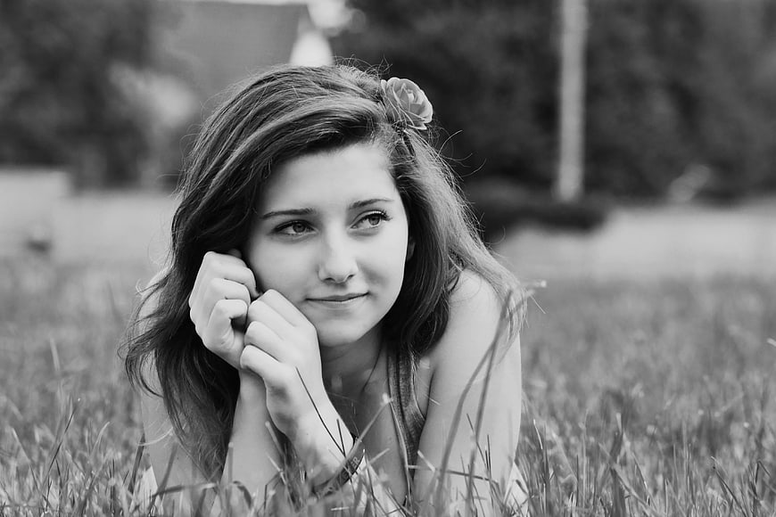 Black and white portrait of woman lying in grass