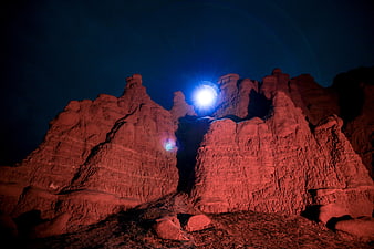 Red Rock Formations Illuminated by Bright Moonlight at Night