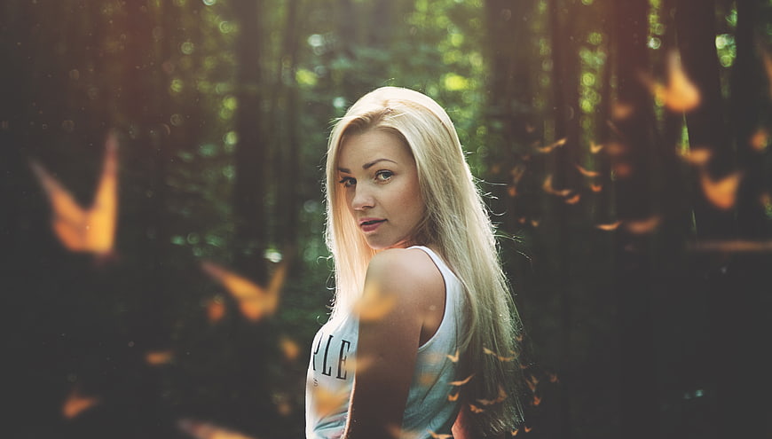 Blonde Woman in Forest with Flying Butterflies