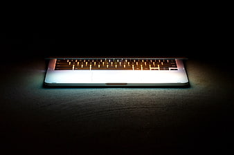 Illuminated Laptop Keyboard on Dark Surface