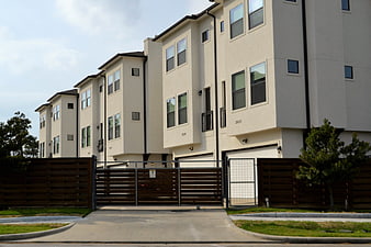 Modern beige townhouses with gated driveway entrance