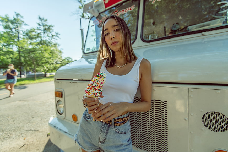 Stylish Woman Eating Sprinkle Ice Cream Cone by Food Truck