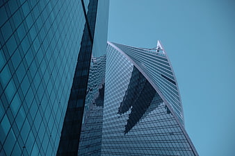 Low angle view of modern glass skyscrapers against a clear blue sky