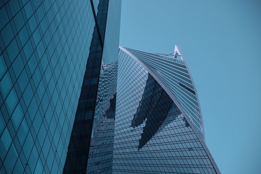 Low angle view of modern glass skyscrapers against a clear blue sky