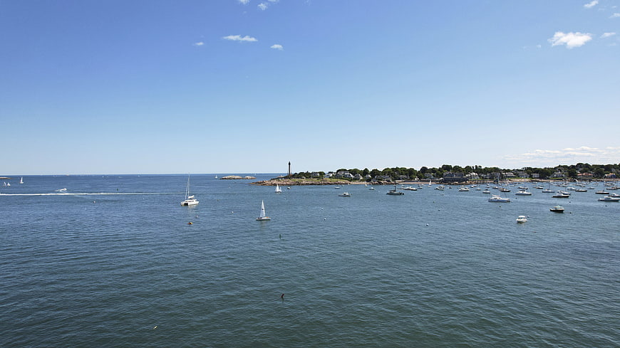 Wide aerial view of sailboats and motorboats in a calm blue harbor