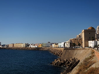 Sunny coastal cityscape with historic architecture and blue sea