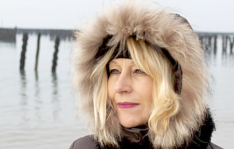 Portrait of mature woman in fur hat by water