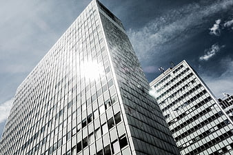 Low angle view of modern glass skyscrapers against blue sky