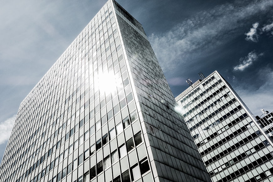 Low angle view of modern glass skyscrapers against blue sky