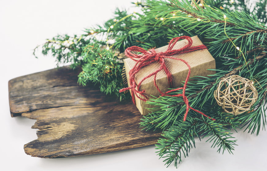 Rustic Christmas Gift Box on Wooden Board with Pine Branches