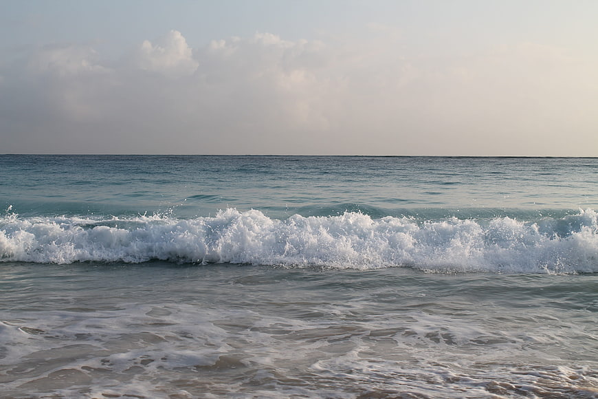 Ocean Wave Breaking on Sandy Beach at Sunset