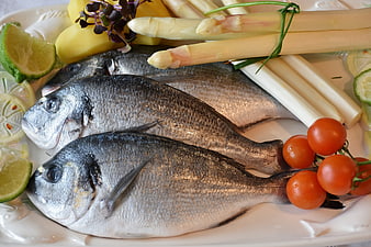 Fresh raw sea bream fish with white asparagus and vegetables