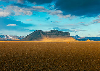 Vast Desert Landscape with Mountain Peak and Blue Sky