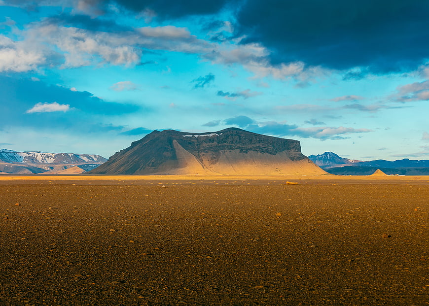 Vast Desert Landscape with Mountain Peak and Blue Sky