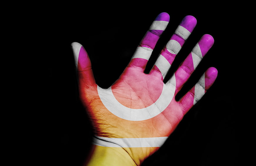 Hand with projected flag design on black background
