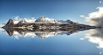 Snow-Capped Mountain Range Reflected in Calm Fjord Water