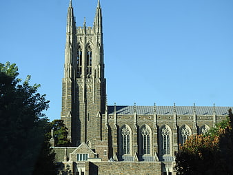 Gothic stone church tower against clear blue sky