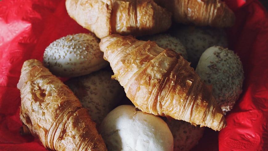 Fresh Croissants and Sesame Buns on Red Cloth