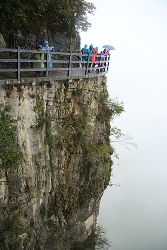 Tourists in Raincoats on Cliffside Plank Road in Enshi