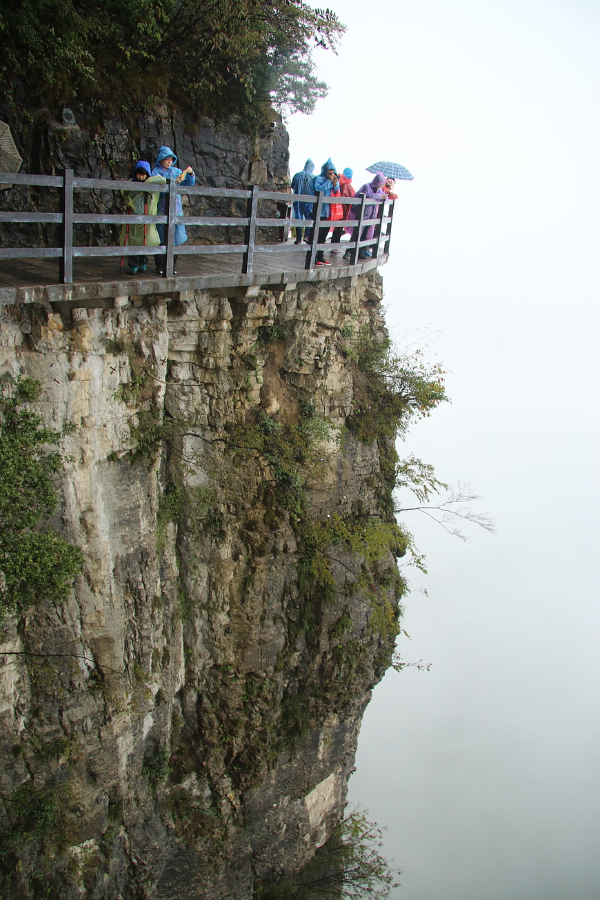 Tourists in Raincoats on Cliffside Plank Road in Enshi