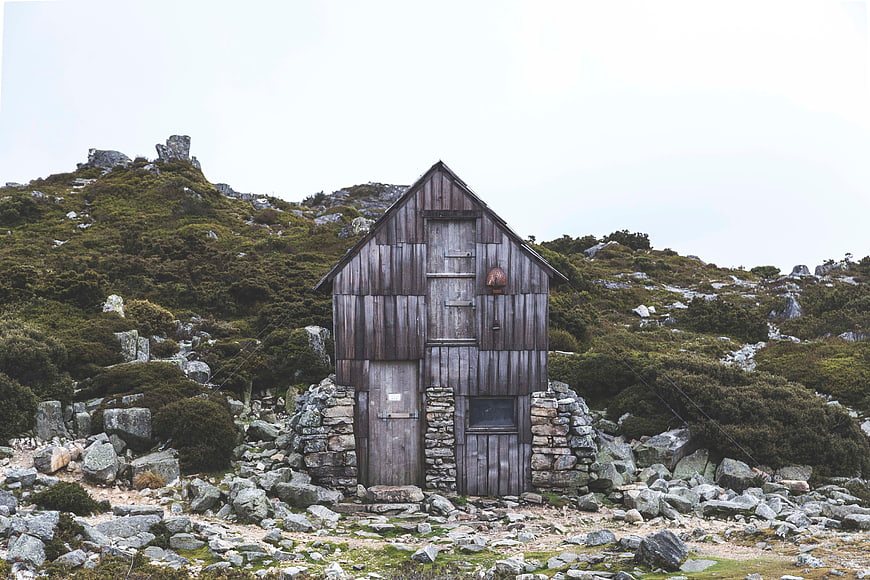 Rustic wooden cabin on rocky mountain landscape