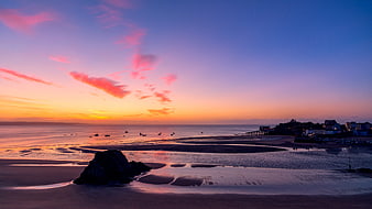 Colorful Sunset Over Tenby Beach with Silhouetted Rock and Pier